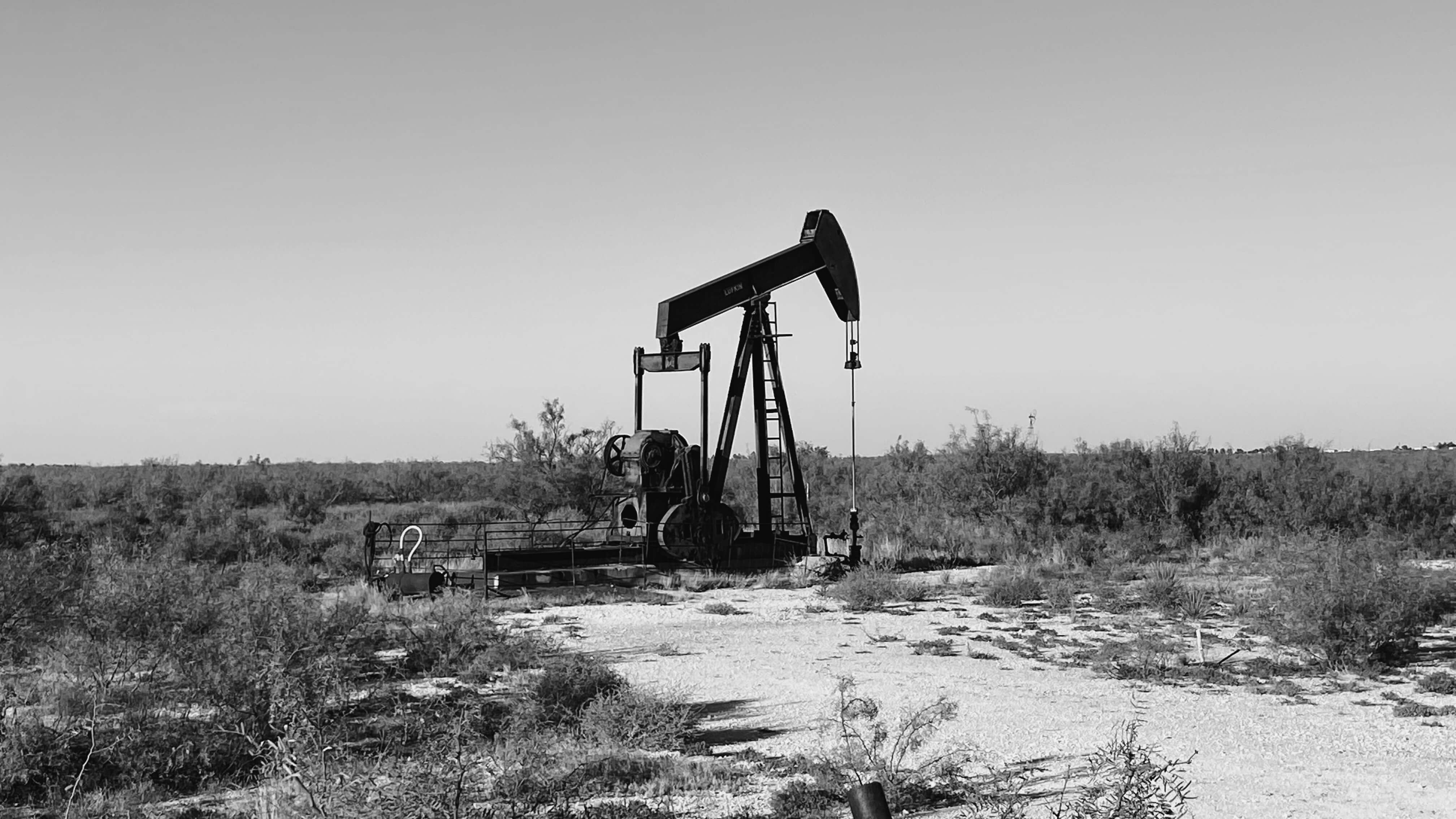 Black-and-white photograph of an oil pumpjack in Midland, Texas. Source: Unsplash