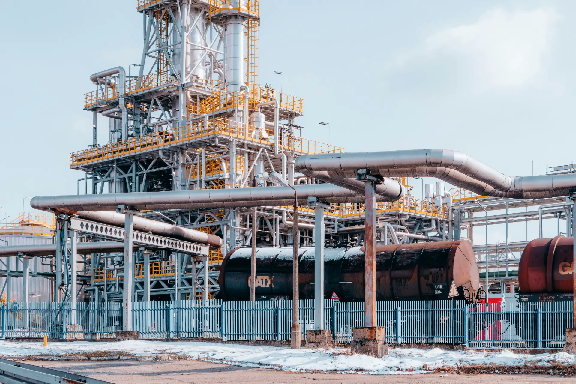 Interconnected steel pipes and processing towers at an oil refinery in Trzebinia, Poland. Photo by Jakub Pabis on Unsplash